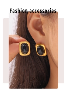 Detail of vintage oval black stone earrings with gold square base on a model