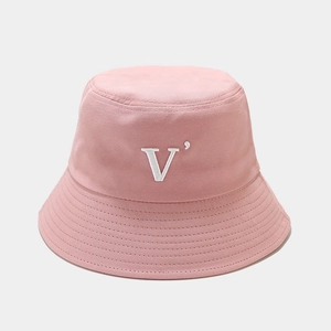 Détail du logo 'V' blanc brodé sur un chapeau bob en coton rose avec coutures fines