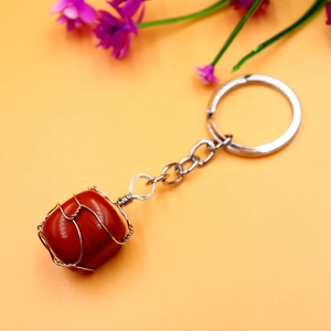 Detail of red jasper stone keychain with handmade silver wire wrap on orange background