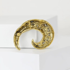 Macro view of the textured golden geometric brooch back with a secure pin clasp closure