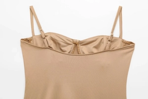 Detailweergave van nude satijnen bodysuit met verstelbare bandjes en sweetheart hals