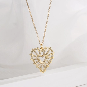 Detailed view of a gold heart pendant with radiating micro-pave stones on a fine chain