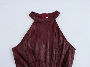 Dettaglio ravvicinato dell'abito in PU bordeaux con scollo all'americana e etichetta taglia S
