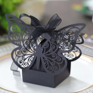 Detailed macro view of black hollow butterfly wedding candy box with a silk ribbon bow