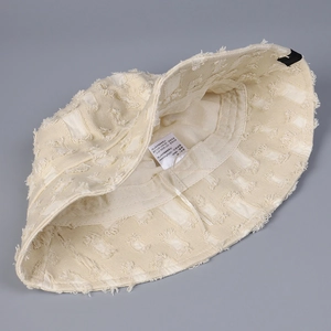 Détail de l'intérieur du bob avec l'étiquette de taille 58 cm et les conseils de lavage