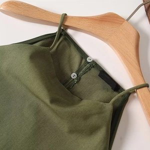 Detail of army green linen top featuring halter neck with double button closure on wood hanger