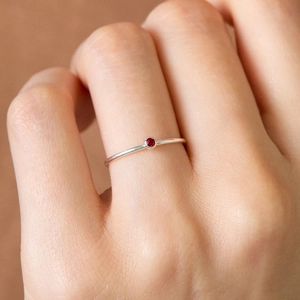 Silver stainless steel ring with a round red gemstone in a minimalist bezel setting