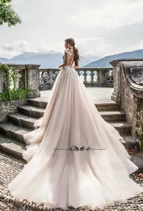 Détail du dos d'une robe de mariée avec broderie en dentelle et longue traîne en tulle