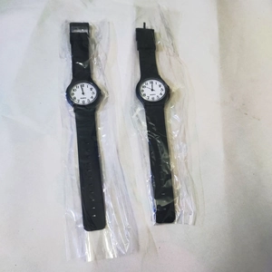 Detail view of two silent black quartz watches with silicone straps in protective bags