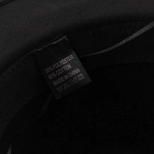 Detail of the interior label showing material blend 65% cotton and 35% polyester on black hat