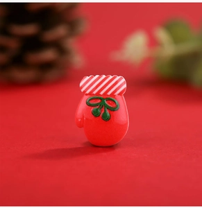 Macro shot of red Christmas glove resin charm with green bow for DIY accessories