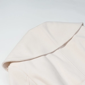 Close-up of off-white wide lapel wool coat showing fine fabric texture and stitching