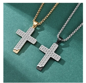 Close-up of gold and black cross pendants with honeycomb cutout on square box chains