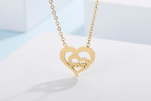 Detailed close-up of golden stainless steel double heart pendant with MOM lettering