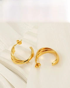 Close-up of golden 18K plated titanium steel earrings with multilayered round design