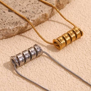 Macro detail of gold and silver spiral spring pendants on stylish snake chains