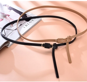 Detail view of stylish thin black and khaki leather belts with elegant gold buckles