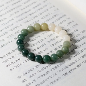 Detail of gradient green Bodhi root beads bracelet laid on an open book page