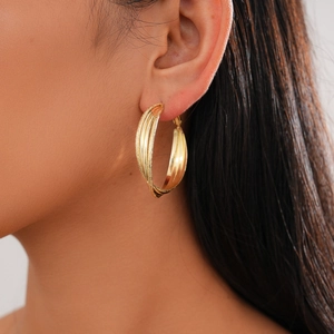 Close-up of model wearing 18k gold plated geometric layered hoop earrings for women