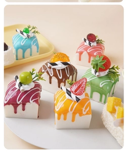 Close-up of realistic mini square cake models with colorful icing and fruit toppings