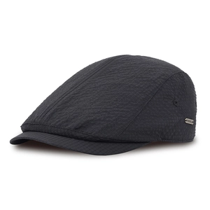 Detail of black breathable flat cap showing seersucker texture and metal side logo