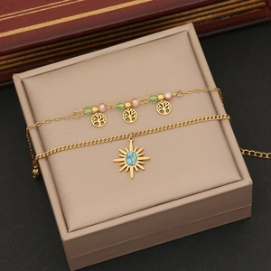 Detail of gold double-layer anklet with Tree of Life charms and sun turquoise pendant