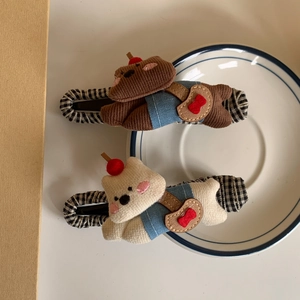 Detailed view of plush teddy bear hair clips with corduroy texture and blue outfits