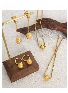 Macro view of gold plated bead jewelry set including necklace, earrings and bracelet
