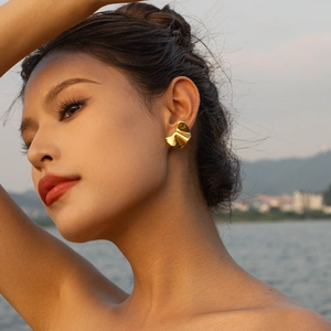 Golden 18k stainless steel irregular earrings worn by a model in nature setting