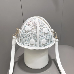 Detailed view of mushroom-shaped white leather handbag with sparkling rhinestone embellishments