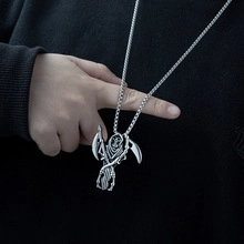 Detailed close-up of a silver grim reaper scythe pendant on a titanium steel cuban chain