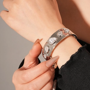Détail d'un bracelet jonc argenté goutte d'eau avec pierres de lune blanches sur poignet