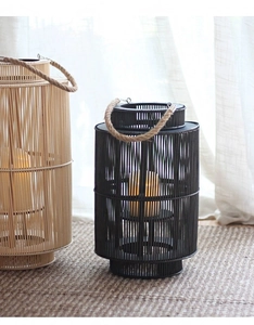 Detail of hand-woven cylindrical bamboo lanterns with rustic hemp rope handles and warm light