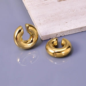Close-up of hollow 18K gold-plated titanium steel C-shape thick hoop earrings on stone