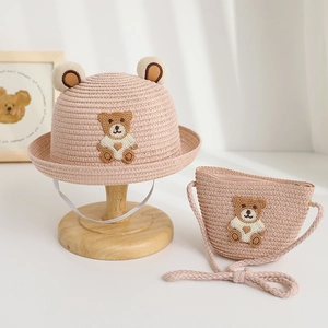 Detail von rosa Strohhut und passender Bärtasche mit niedlichen Häkelapplikationen