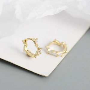 Macro view of gold s925 silver hoop earrings with marquise-cut white zircon inlays
