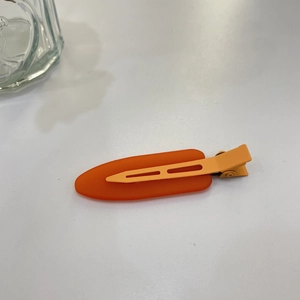 Detail of candy color jelly hair clip with a contrast orange and yellow duckbill design