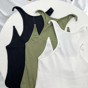 Flat lay of ribbed knit tank tops in black, military green and white on a clean white surface