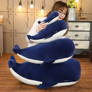 Soft blue whale plush toys in four different sizes stacked in a cozy home setting