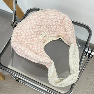 Detailed embroidery of white daisies on a pink mesh shoulder bag with a logo label