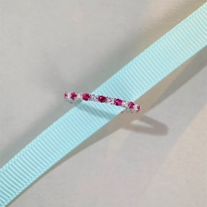 Close-up of S925 silver ring with red and white gemstones on a blue ribbon
