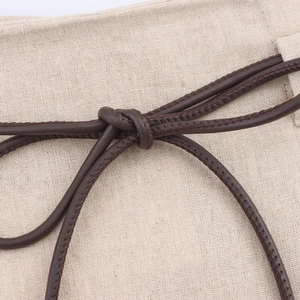 Dettaglio gonna in lino beige con coulisse in pelle testa di moro e nodo decorativo