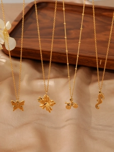 Detailed view of golden butterfly and seahorse pendants on fine chain necklaces