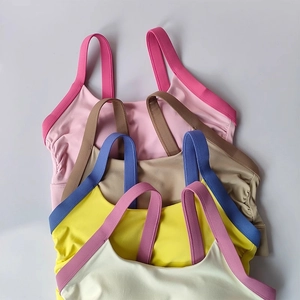 Vertical stack of yoga bras in pink, brown, yellow, and cream with gathered sides