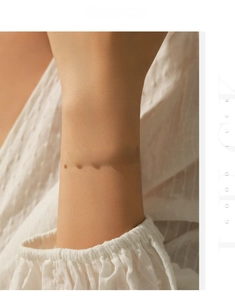 Close-up of s925 silver cross bracelet with red agate inlay on model wrist
