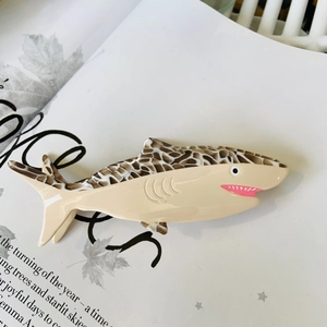 Detail of penguin shaped hair claw clip with beige and brown tortoiseshell acetate finish