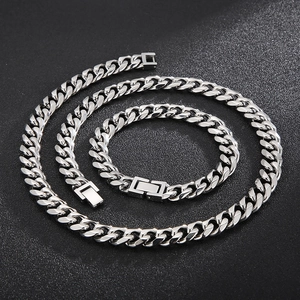 Close-up of silver Cuban link necklace and bracelet set with secure box clasp design