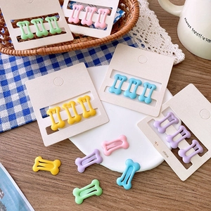 Detail of colorful bone-shaped hair clips in pastel macaron shades on card