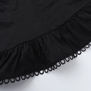 Detail of black camisole featuring ruffled hem and circular hollow lace craftsmanship