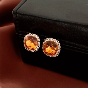 Vue macro de boucles d'oreilles carrées en ambre plaqué or 18 carats et zircons fins